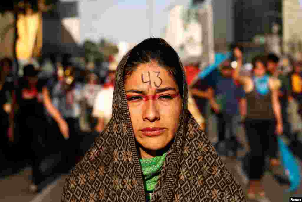 A woman takes part in a march to mark the 29th month anniversary of the disappearance of the 43 students of Ayotzinapa College Raul Isidro Burgos a in the state of Guerrero in Mexico City, Mexico, Feb. 26, 2017.