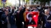 FILE - Relatives of detained military officers hold a portrait of Mustafa Kemal Ataturk, founder of modern Turkey, shouting slogans in front of a courthouse in Ankara, Oct. 9, 2013. 