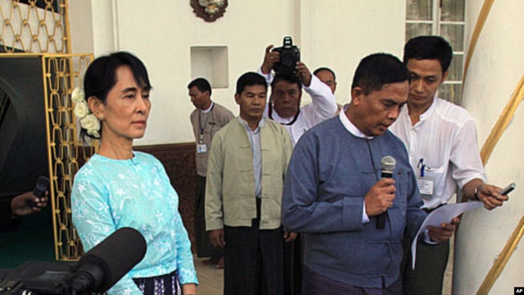 Burma's Labor Minister, Aung Kyi, right, reads out a statement after meeting with democracy leader Aung San Suu Kyi, left, during a press conference in Yangon, Burma, October 30, 2011.