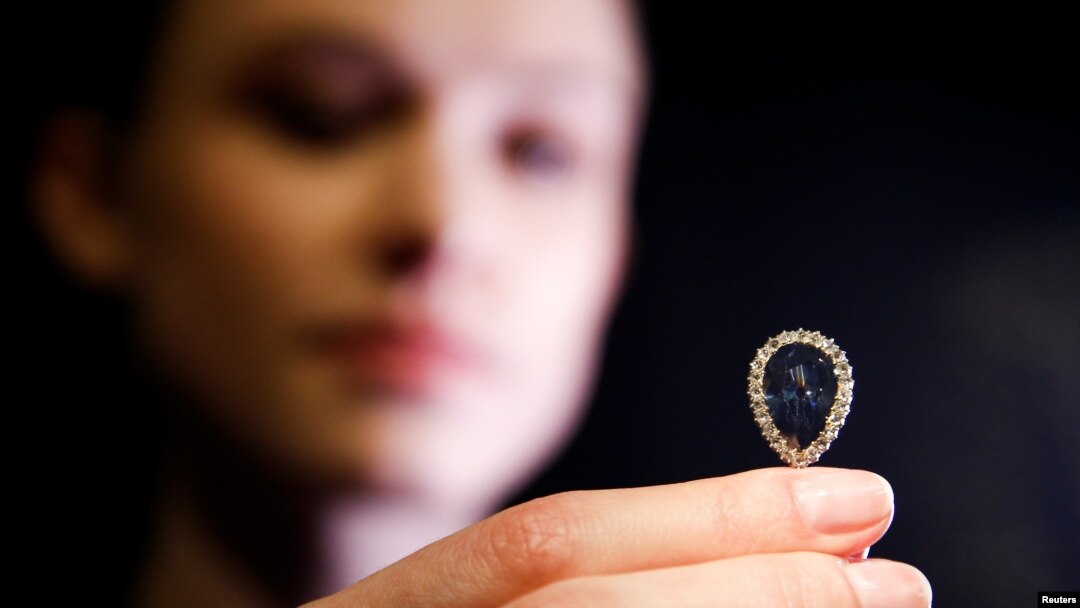 FILE - A model poses with The Farnese Blue diamond at Sotheby's auction house in London, Britain, April 6, 2018.