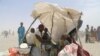 FILE - A handout photo released by the World Food Program shows women and children evacuated from the islands of Lake Chad sitting under a makeshift tent in N'Guigmi, Niger, May 5, 2015. The U.N. Security Council on March 3, 2017, kicked off a visit to spotlight Africa's worst humanitarian crisis as millions face hunger amid the Boko Haram insurgency in Nigeria and the Lake Chad region.