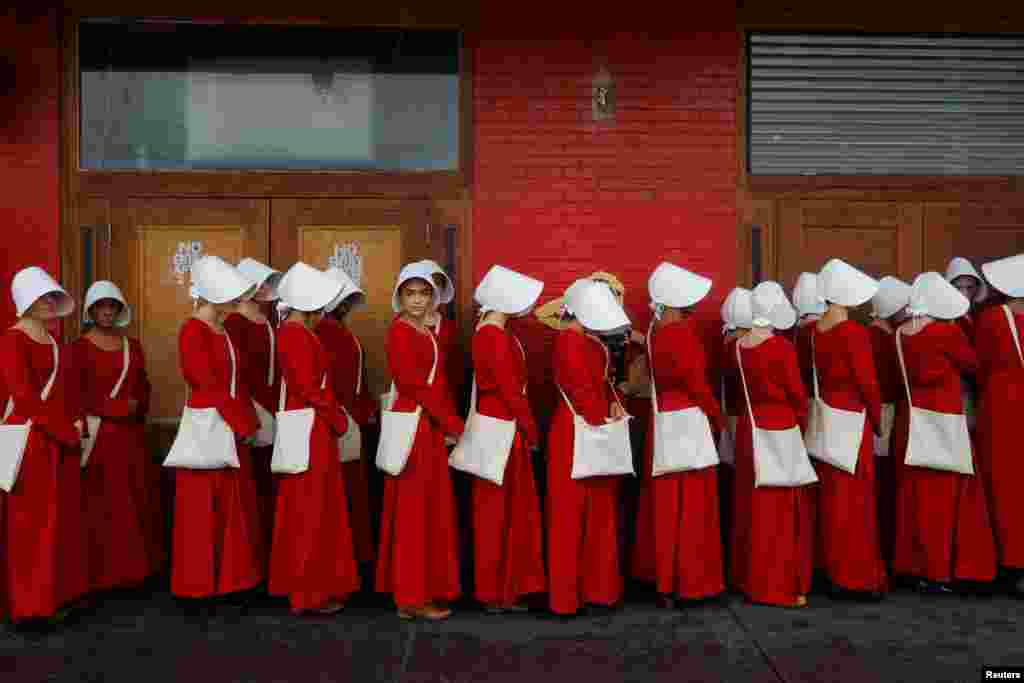 Women dressed as handmaids promoting the Hulu original series "The Handmaid's Tale" stand along a public street during the South by Southwest (SXSW) Music Film Interactive Festival 2017 in Austin, Texas, USA, March 11, 2017.
