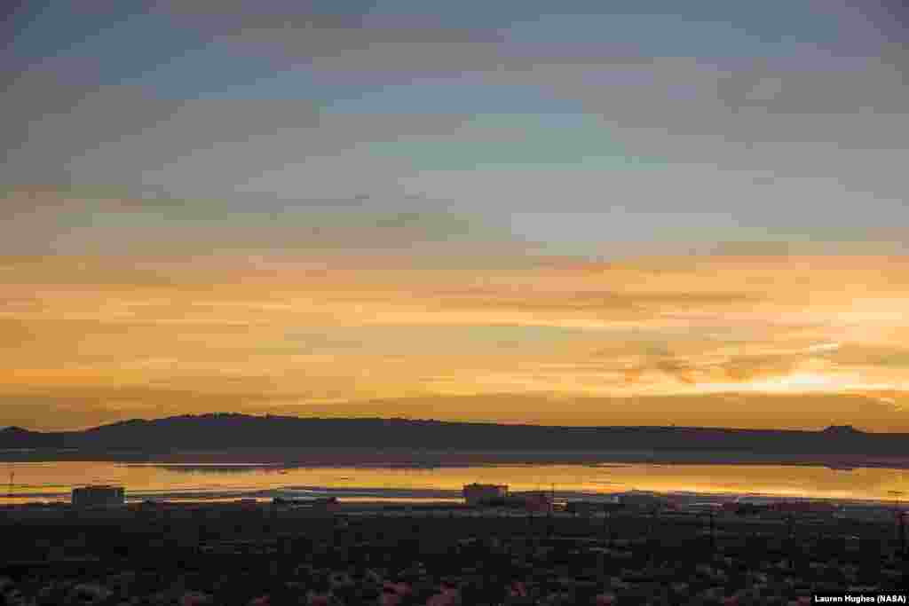 A sunrise photo of Edwards Air Force Base’s Rogers Dry Lake was taken after heavy rainfall in southern California. NASA’s Armstrong Flight Research Center is seen in the foreground.