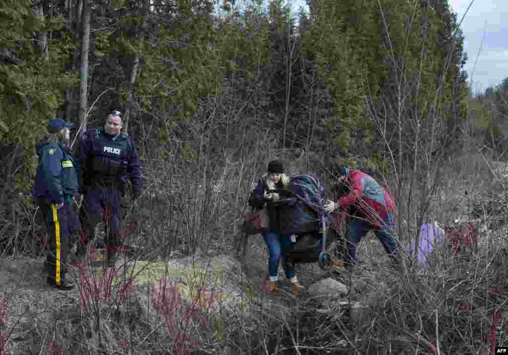 A couple who claimed to be from Turkey struggles to get their baby and baby carriage across the U.S.-Canada border in Champlain, New York.