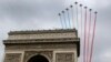 France's national colors trail above the Arc de Triomphe during the traditional Bastille Day parade on the Champs Elysees in Paris, July 14, 2014.