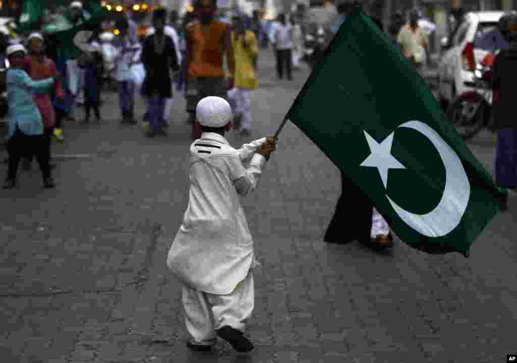 An Indian Muslim boy holds a religious flag and walks in a procession to mark the birth anniversary of Prophet Mohammed in Mumbai.