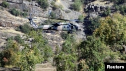 FILE - A Turkish military helicopter flies at low altitude along a mountain in Cukurca, near the Iraqi border in southeastern Turkey, where thousands of Turkish troops had launched a ground and air offensive against PKK fighters, Oct. 21, 2011.