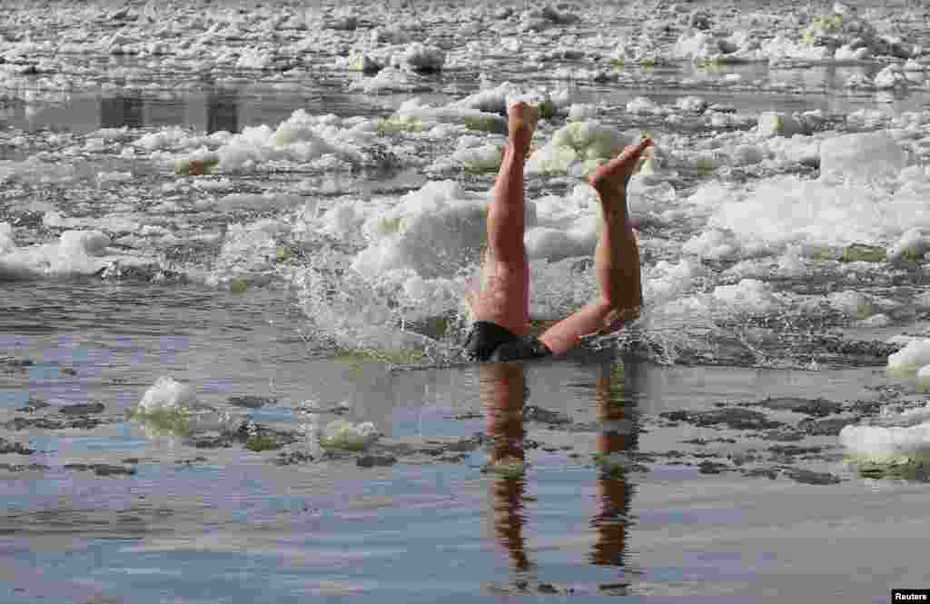 A member of the "Yenisei walruses" winter swimming club Alexander Alexandrov, 39, dives on the Yenisei River in Krasnoyarsk, Russia.