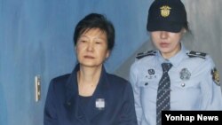 박근혜 전 한국 대통령이 지난해 10월 서울중앙지법에서 열린 공판에 출석하기 위해 호송차에서 내려 법정으로 향하고 있다. 