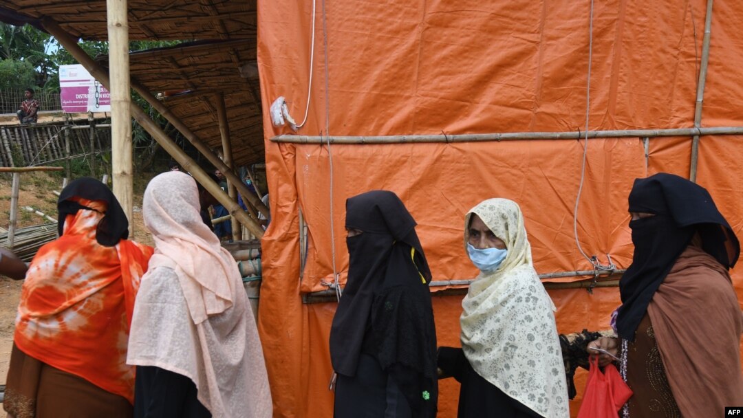 Rohingya refugees wait in to collect relief supplies at Kutupalong refugee camp in Ukhia, Bangladesh, Oct. 15, 2020. 