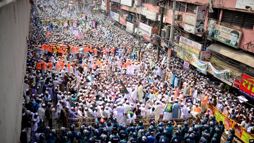 Supporters of Islami Andolan Bangladesh, an Islamist political party, face policemen during a protest against French President Emmanuel Macron and against the publishing of caricatures of the Prophet Muhammad they deem blasphemous, Dhaka, Oct. 27, 2020.