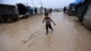 An internally displaced Syrian boy walks through the Bab Al-Salam refugee camp, near the Syrian-Turkish border, northern Aleppo province, Syria, Dec. 26, 2016.