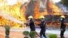 Firefighters spray water as flames and smoke rise from burning illegal drugs during a destruction ceremony to mark International Day Against Drug Abuse and Illicit Trafficking outside Yangon, Myanmar, June 26, 2020. 