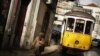 A woman walks near a tram at the Alfama neighborhood in Lisbon, Portugal, January 22, 2013. 
