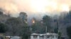 Fire and emergency crew battle bushfire near a house in the rural town of Canungra in the Scenic Rim region of South East Queensland, Australia, Sept. 6, 2019.
