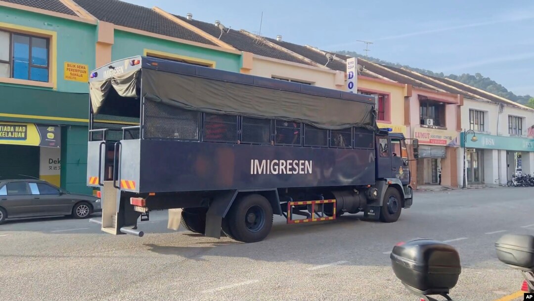 In this image taken from a video, an immigration truck with unidentified people onboard is driven on a road that leads to Lumut Naval Base Tuesday, Feb. 23, 2021 in Lumut, Malaysia.