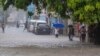 Gente camina por una calle inundada por las lluvias de la tormenta tropical Franklin en Santo Domingo, República Dominicana, el martes 22 de agosto de 2023.