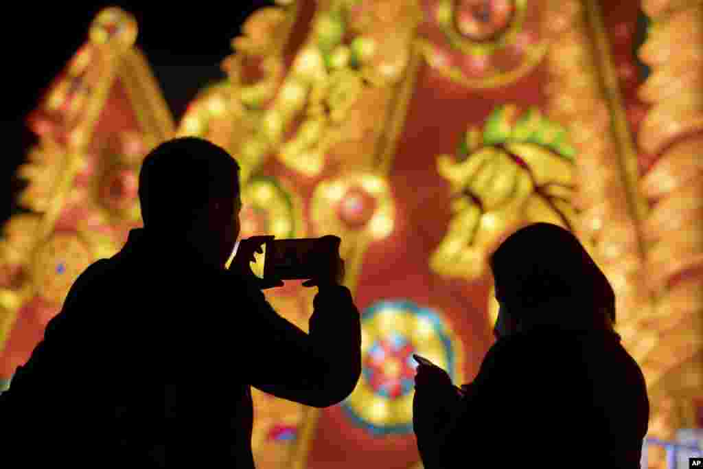 A visitor takes a smartphone photo of a lighted display celebrating the Lantern Festival at a park in Beijing. Saturday is the Lantern Festival in China, the final day of the annual celebration of the Chinese Lunar New Year. 