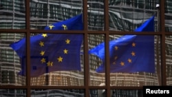 FILE - European Union flags at the EU headquarters in Brussels. 
