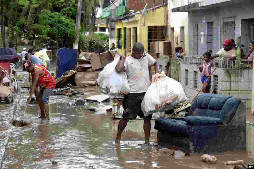 Residents of the city of Barreiros try to save their belongings form their homes affected by floods, due to heavy rains in Pernambuco state, northeastern Brazil.