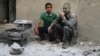 A man covered with dust sits on a street following a reported airstrike by Syrian government forces in the rebel-held neighborhood of Sukkari in the northern city of Aleppo, May 30, 2016.
