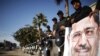Policemen stand guard near a poster outside the constitutional court put up by supporters of Egyptian President Mohamed Mursi as they stage a sit-in, in Cairo December 23, 2012. 