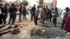 Security officials assess the scene of a bomb blast that killed four people by suspected members of Nigerian Islamist sect Boko Haram in Nigeria's northern city of Kaduna, April 8, 2012.