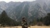 FILE - An Afghan security force personnel keeps watch near his check post in Parun, capital of Nuristan province, Afghanistan.