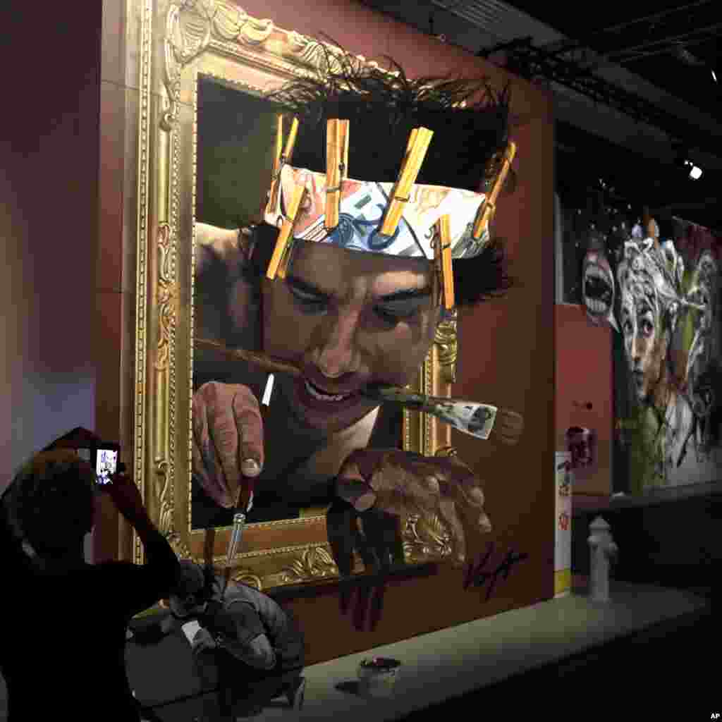A woman takes pictures of a work by Mexican artist Juandres Vera at the Magic City 'The Art of the Street exhibition' in Munich, Germany.
