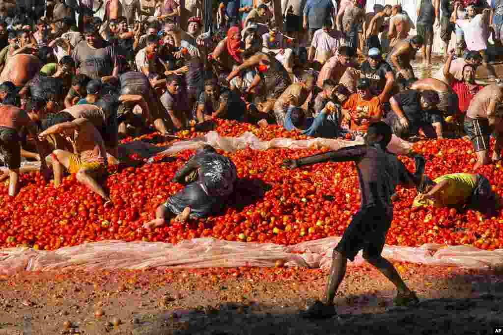 People throw tomatoes at each other during the Summer Fest in Quillon, some 300 miles south of Santiago, Chile, Feb. 18, 2017.