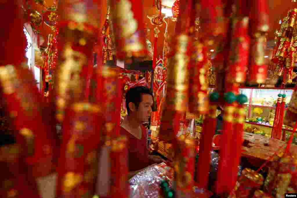 A man is seen selling goods in a decorations market during Lunar New Year eve in Phnom Penh, Cambodia.