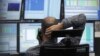 A trader makes a phone call at his desk at the Frankfurt stock exchange, July 24, 2012. 