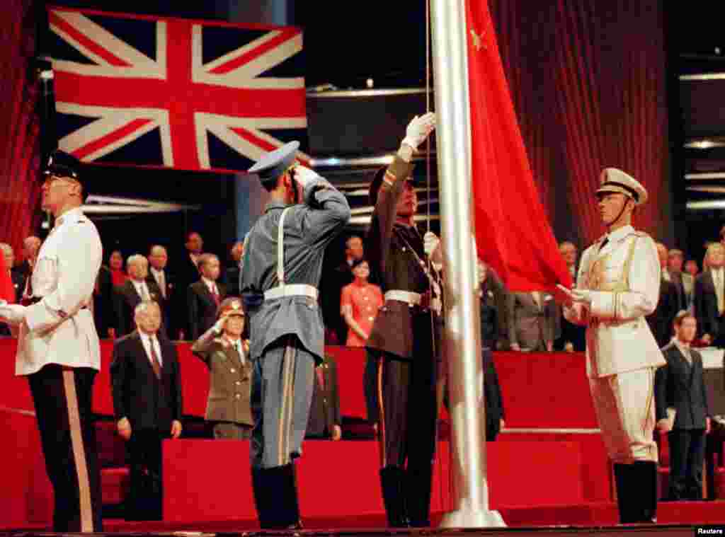 The Chinese flag is raised by People's Liberation Army soldiers to signal Hong Kong's return to Chinese sovereignty after 156 years of British rule, in Hong Kong, July 1, 1997. 