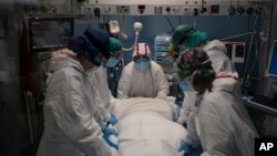 A medical team prepares to rotate a COVID-19 patient in the ICU of the Hospital del Mar, in Barcelona, Spain, Jan. 19, 2021.