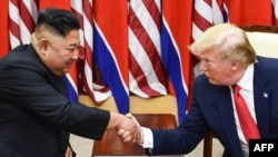 FILE - In this photo taken on June 30, 2019, North Korea's leader Kim Jong Un and US President Donald Trump shake hands during a meeting on the south side of the Military Demarcation Line that divides North and South Korea.