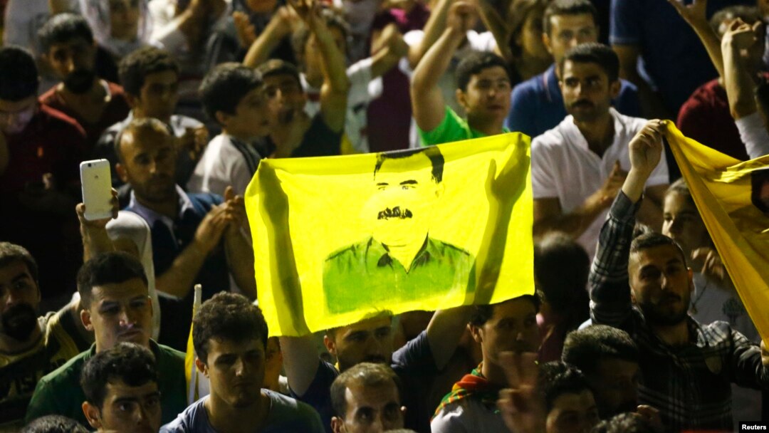 Supporters hold a flag with the image of Abdullah Ocalan, jailed leader of the Kurdistan Workers' Party (PKK) as they celebrate outside the pro-Kurdish Peoples' Democratic Party (HDP) headquarters in Diyarbakir, Turkey, June 7, 2015. 