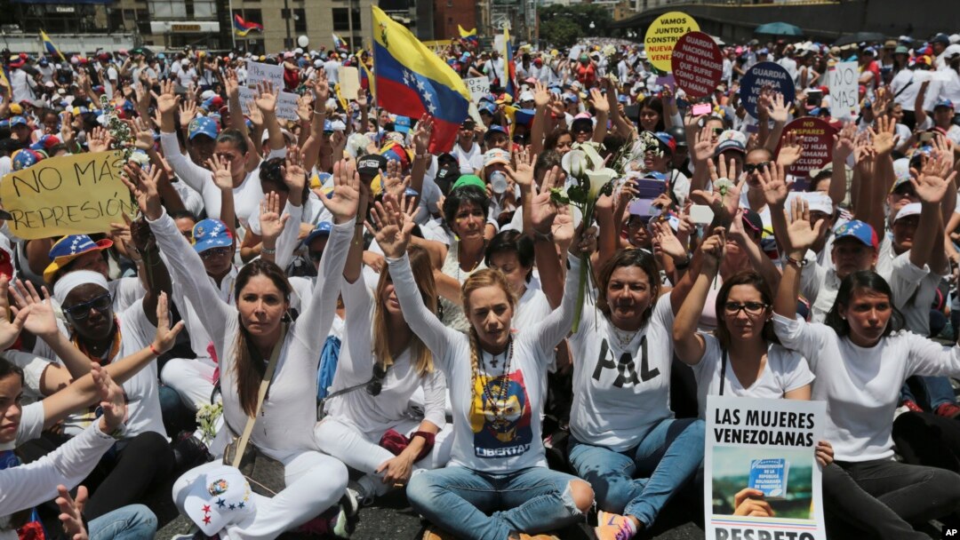 Lilian Tintori, front fourth from right, wife of jailed opposition leader Leopoldo Lopez, leads a sit-in blocking the Franciso Fajardo highway after a women march against repression was blocked from reaching the Interior Ministry in Caracas, Venezuela, Saturday, May 6, 2017.