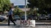 FILE - A man walks past a sign at a clinic run by Doctors Without Borders (MSF) in Port-au-Prince, Haiti, Feb. 3, 2023. MSF reported Nov. 13, 2024, that at least two patients were killed when its ambulance was attacked earlier this week in Port-au-Prince. 
