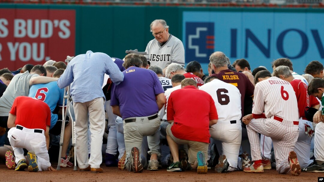 Rev. Patrick J. Conroy, Chaplain of the U.S. House of Representatives, prays as both teams kneel, before the Congressional baseball game, Thursday, June 15, 2017, in Washington. The annual GOP-Democrats baseball game raises money for charity. (AP Photo/Alex Brandon)