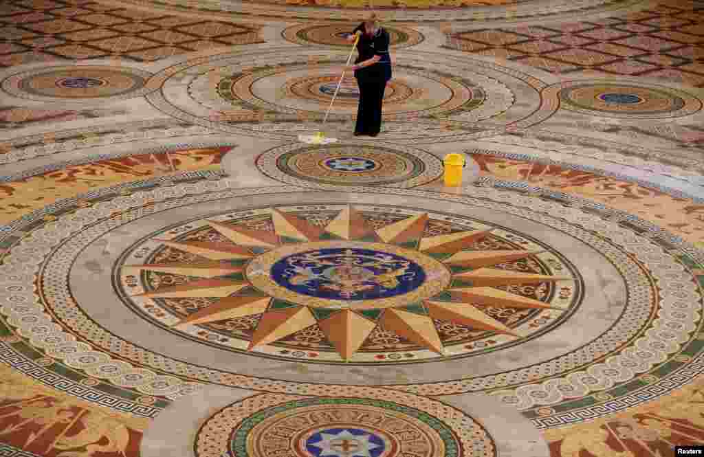 Cleaner Ann Lawler mops the Minton tiled floor of St George's Hall in Liverpool, northern Britain.