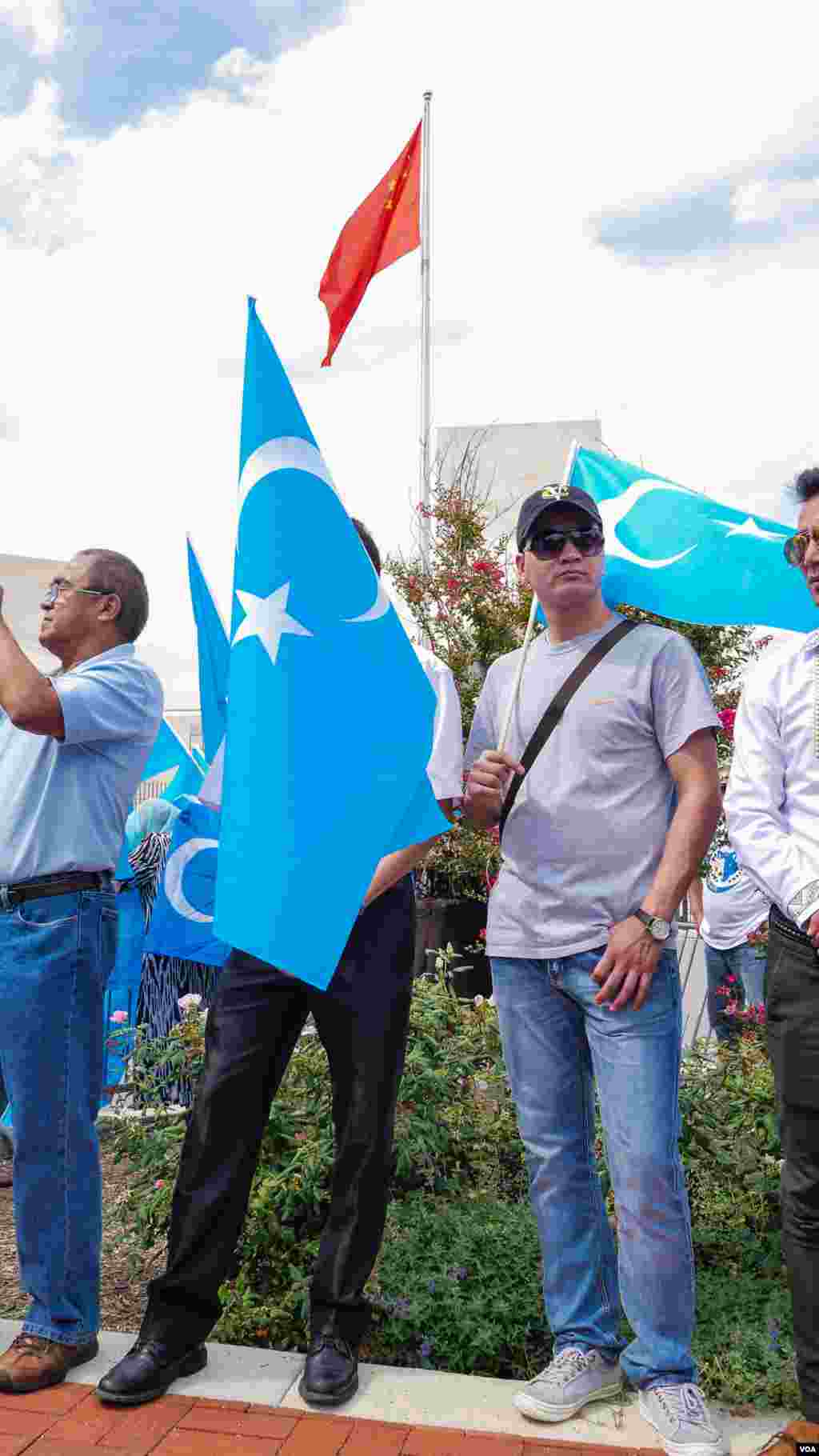 Uyg'urlar Sharqiy Turkiston bayroqlarini ko'tarib, Xitoy elchixonasi qarshisida bu davlatning uyg'urlarga qarshi siyosatini qoralab, namoyish qilmoqda, Vashington, 3-avgust, 2014-yil. Odil Ruzaliev surati