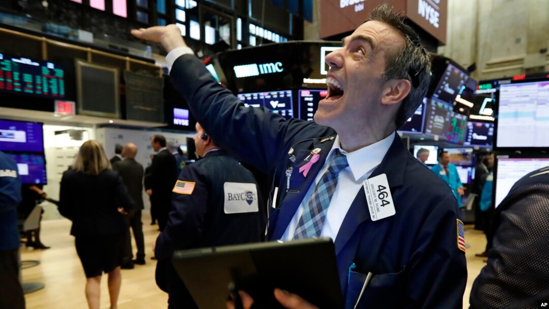 Trader Gregory Rowe reacts with fellow traders as he works on the floor of the New York Stock Exchange, May 1, 2019.