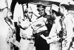 FILE - An Associated Press war correspondent reads a copy of Stars and Stripes aboard the exchange liner Gripsholm, as it arrived at Algiers, in this image provided by the U.S. Signal Corps, May 23, 1944.