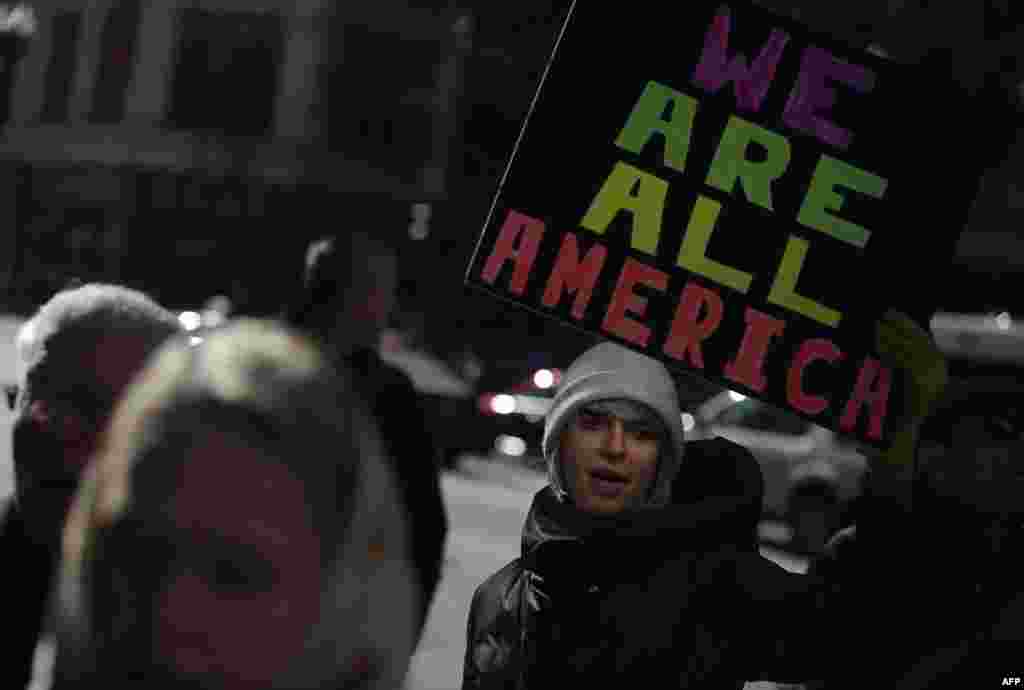 Demonstrators hold up signs during an interfaith solidarity protest against President Donald Trump's executive immigration ban outside the Downtown Islamic Center in Chicago, Illinois.