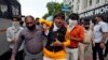 A demonstrator reacts as he is detained by plainclothes policemen during a protest demanding to boycott China-made products in Ahmedabad, India, July 6, 2020. 