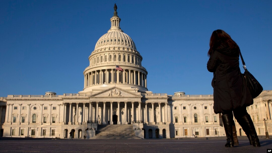 FILE - A woman walks past the U.S. Capitol in Washington. 