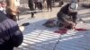 A still image taken from a video posted to a social media website on April 4, 2017, shows a civil defense member helping a child in the town of Khan Sheikhoun after what rescue workers described as a suspected gas attack in rebel-held Idlib.