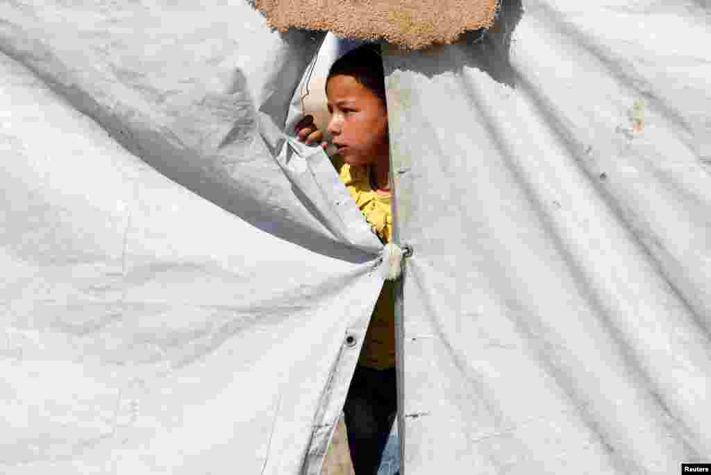 A displaced child, who fled the Islamic State stronghold of Mosul with her family, plays at Khazer camp, Iraq.