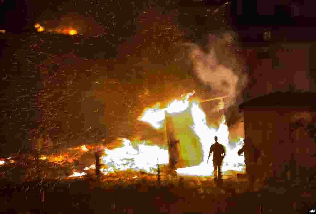 Migrants evacuate as a huge fire blazes through the Grande-Synthe migrant camp outside the northern French city of Dunkirk late April 10, 2017, reducing it to "a heap of ashes", the regional chief said.