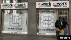 A young couple approach an employment agency in Milan, Italy, April 2, 2012. 